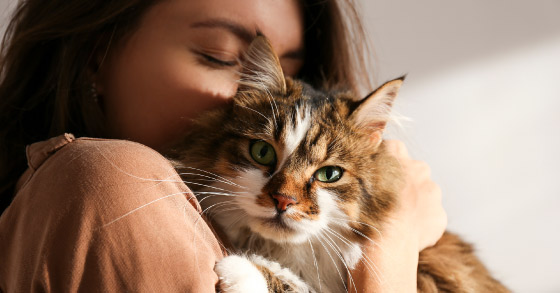 Women hugging her cat tightly. 