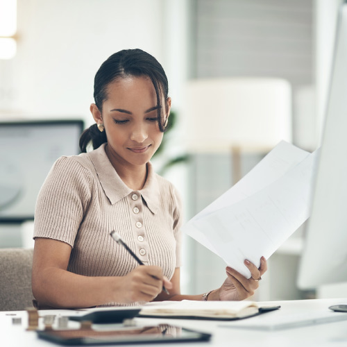 Well-polished young professional sitting in her home office filing her taxes.