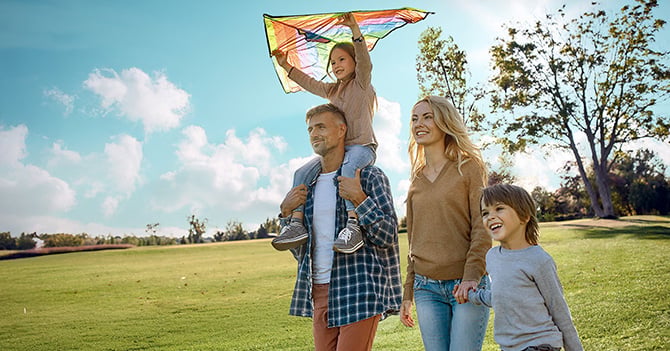 A family flying a kite in the park.
