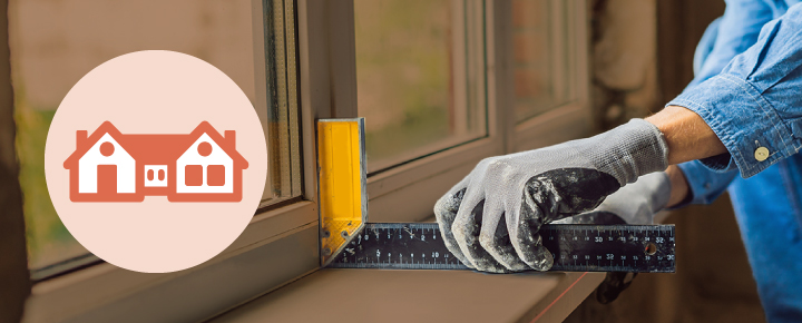 A person takes the measurement of a window.