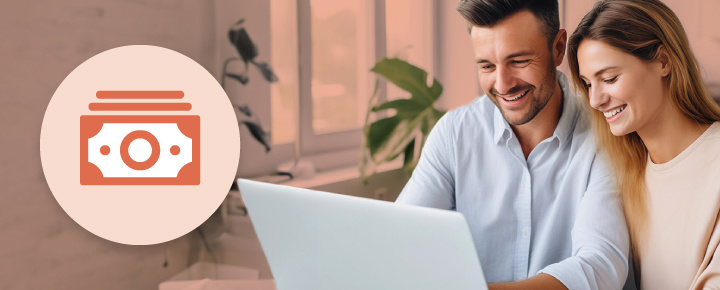 Modern office with a round icon of money on the left and a smiling man and woman looking at a laptop on the right.