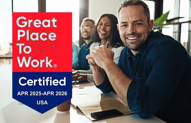 Three smiling people at a meeting with Great Place to Work Certified April 2025-April 2026 USA graphic.