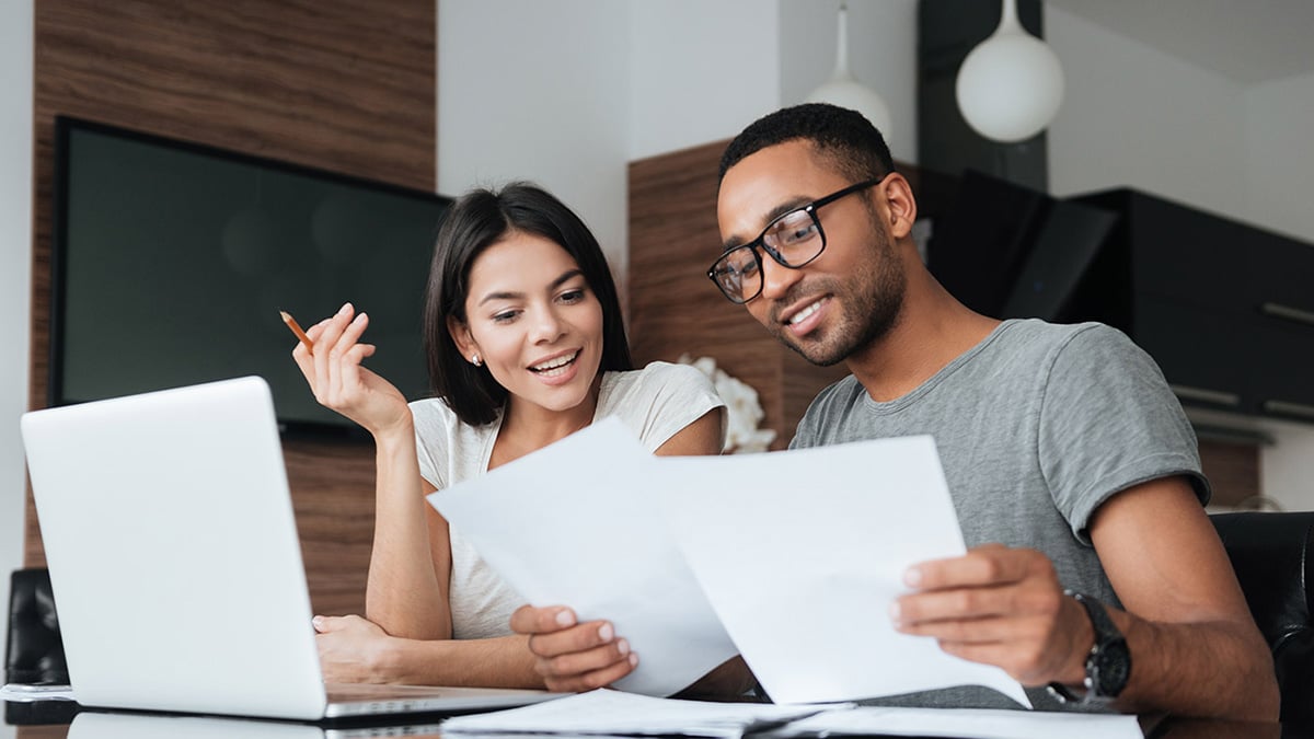Young couple with laptop and financial documents.